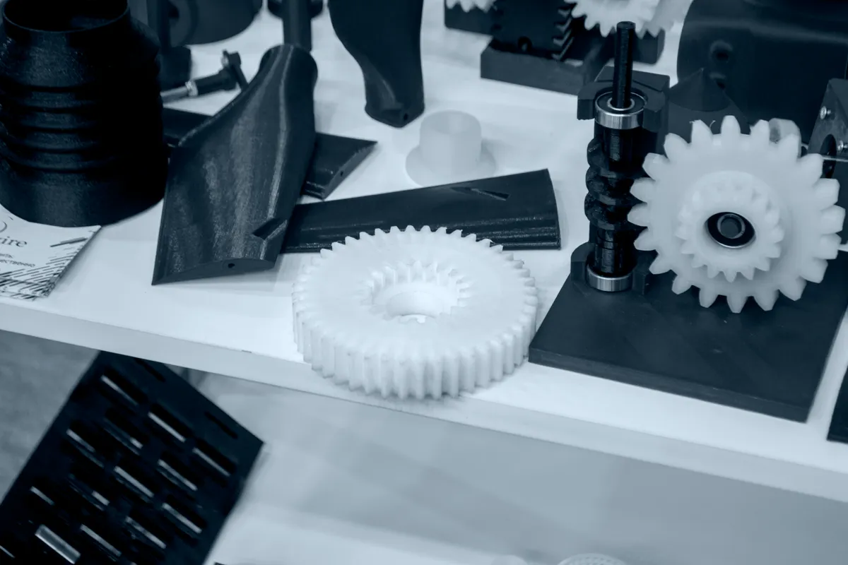 Technische Bauteile aus weißem und schwarzem Kunststoff im 3D-Druck gefertigt